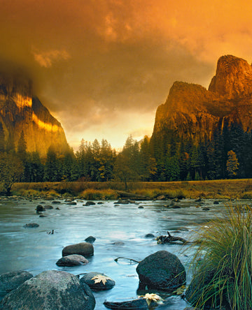 The Peaks at Yosemite National Park at dusk with the Merced River in the foreground.