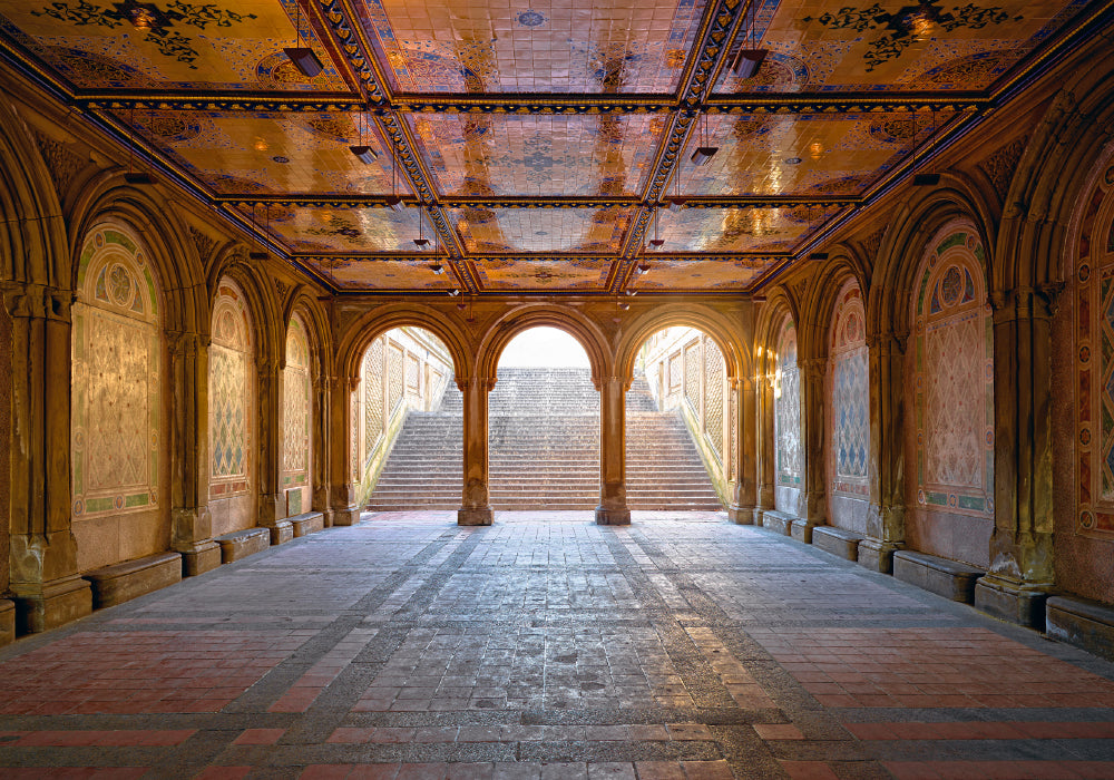 Underground walkway with gold ceilings and arch corridors leading up stairs to Central Park New York