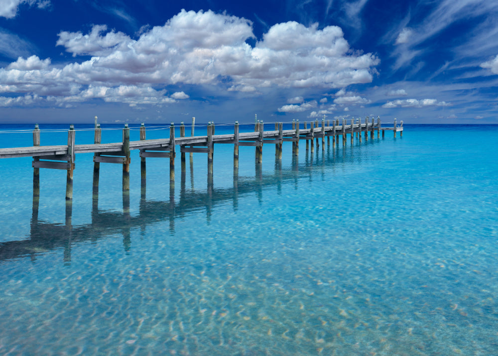 Old wooden jetty with white rope and lanterns leading over a turquoise ocean in Key West Florida
