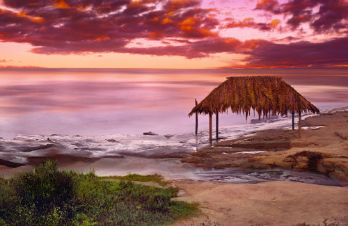 Waves crashing under the pier and onto the beach in La Jolla California on a stormy day