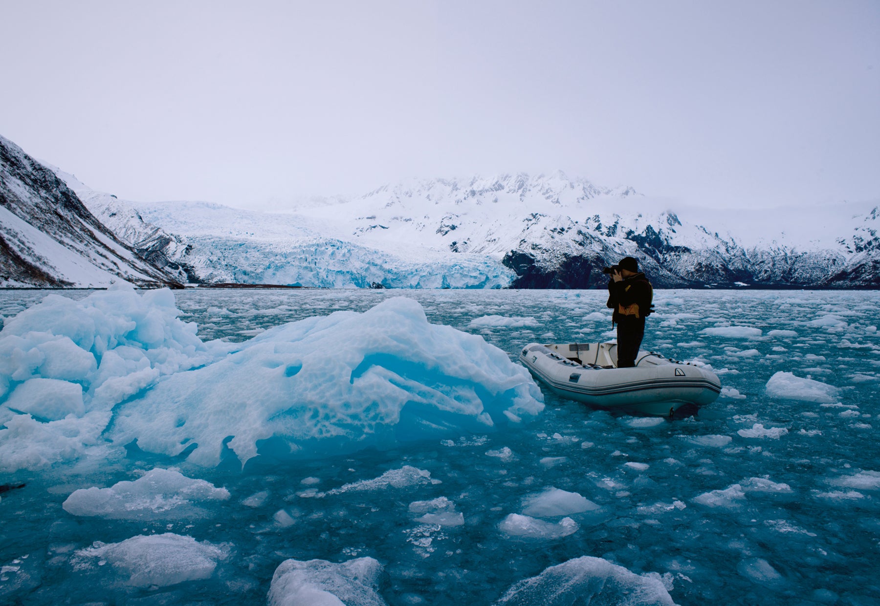 Portrait of Peter Lik standing in a Zodiac inflatable boat in an ocean of broken ice off the coast of Alaska