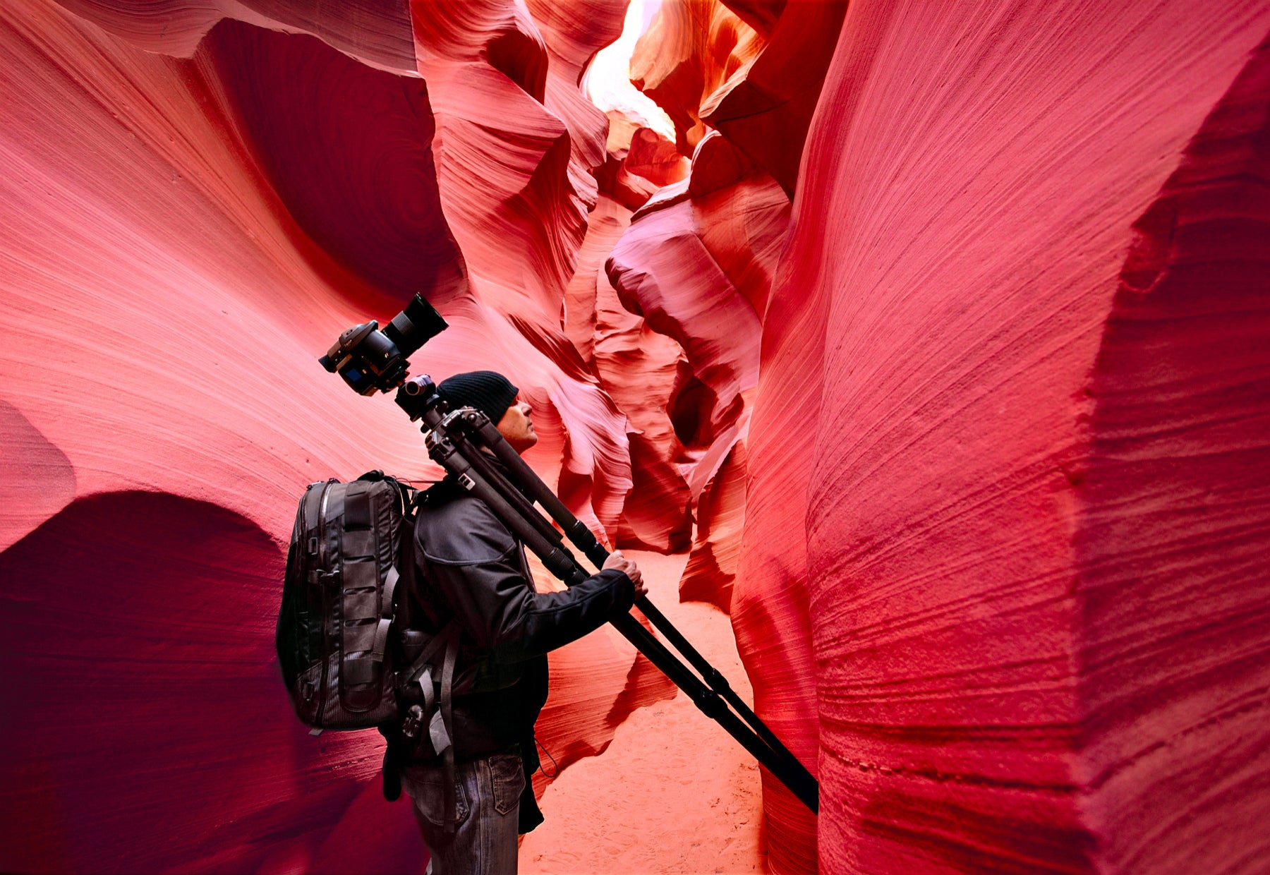 Portrait of Peter Lik with a tripod over his shoulder walking through Antelope Canyon in Page, Arizona.