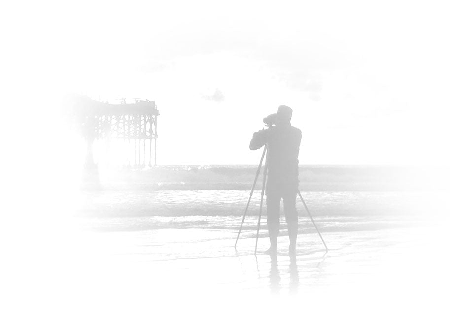 Silhouetted black and white portrait of Peter Lik taking a photograph of the Huntington Beach Pier in California