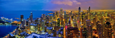 Rooftop view of downtown Chicago and Lake Michigan shoreline lit up at night 