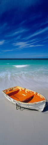 White and orange wooden row boat on the sandy beach of Wineglass Bay Australia