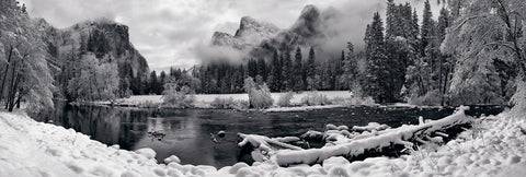 Black and white river running through the snow covered Yosemite Valley with El Capitan mountain in the background 