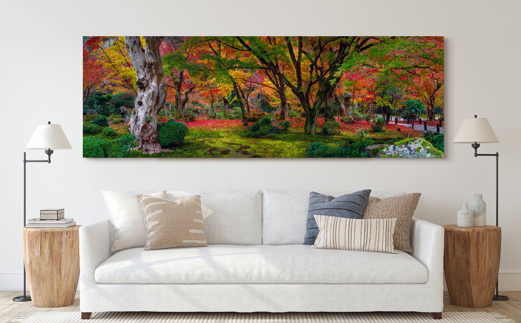 Large photograph of trees with green, yellow, and red leaves photographed by Peter Lik handing on the wall of a living room 