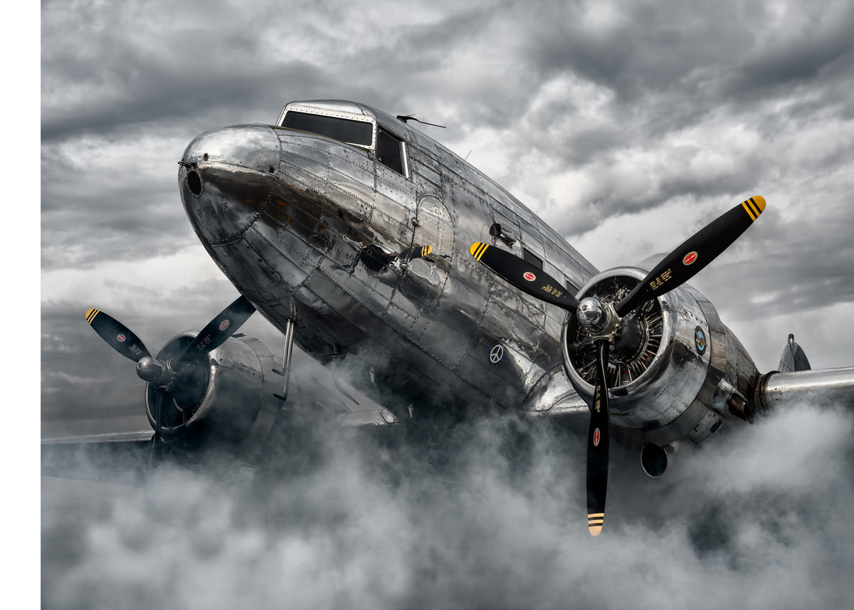 LIK Fine Art photograph by Peter Lik featuring a chrome DC-3 airplane enveloped in mist or fog under a turbulent, stormy sky.