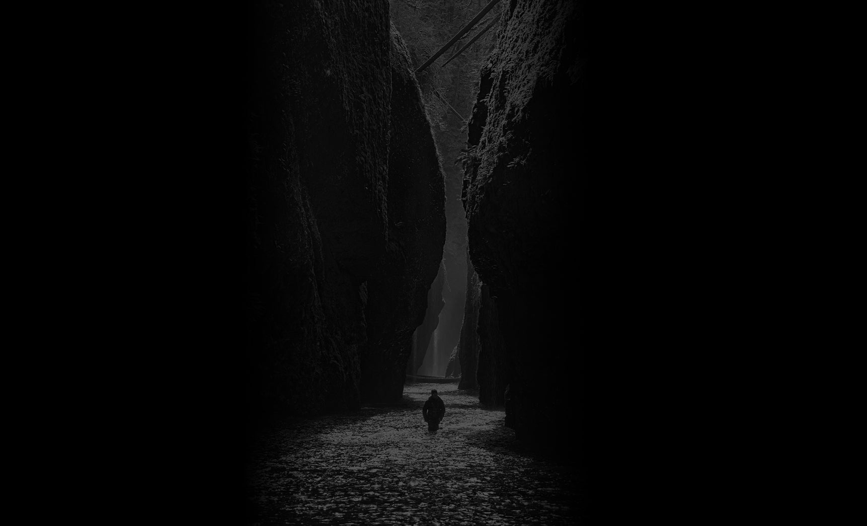 Black and white silhouetted portrait of Peter Lik walking through the waters of the Columbia River Gorge in Oregon