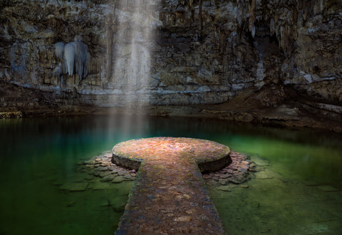 Discover the ethereal beauty of a Mexican cenote, where light dances on emerald waters.