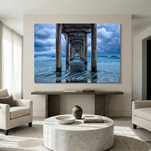 Endless Horizon by LIK Fine Art showing Scripps Pier in La Jolla with silky ocean waves and dramatic storm light hanging in a living room.