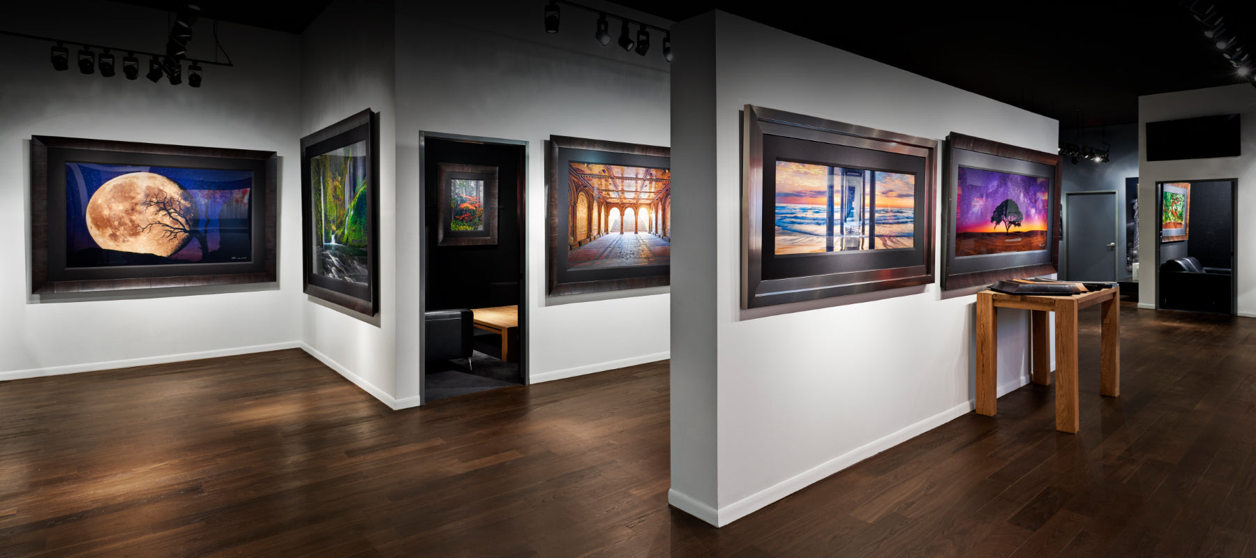 LIK Fine Art Gallery interior with white and gray walls and brown wood floors displaying framed photography by Peter Lik