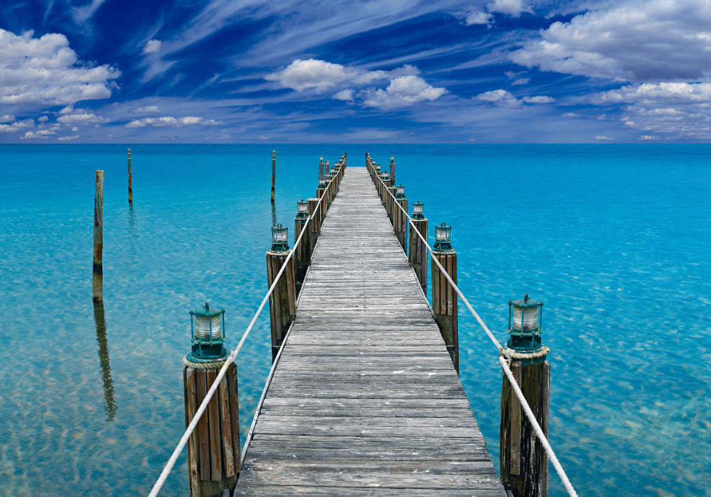 Old wooden jetty with white rope and lanterns leading over a turquoise ocean in Key West Florida 