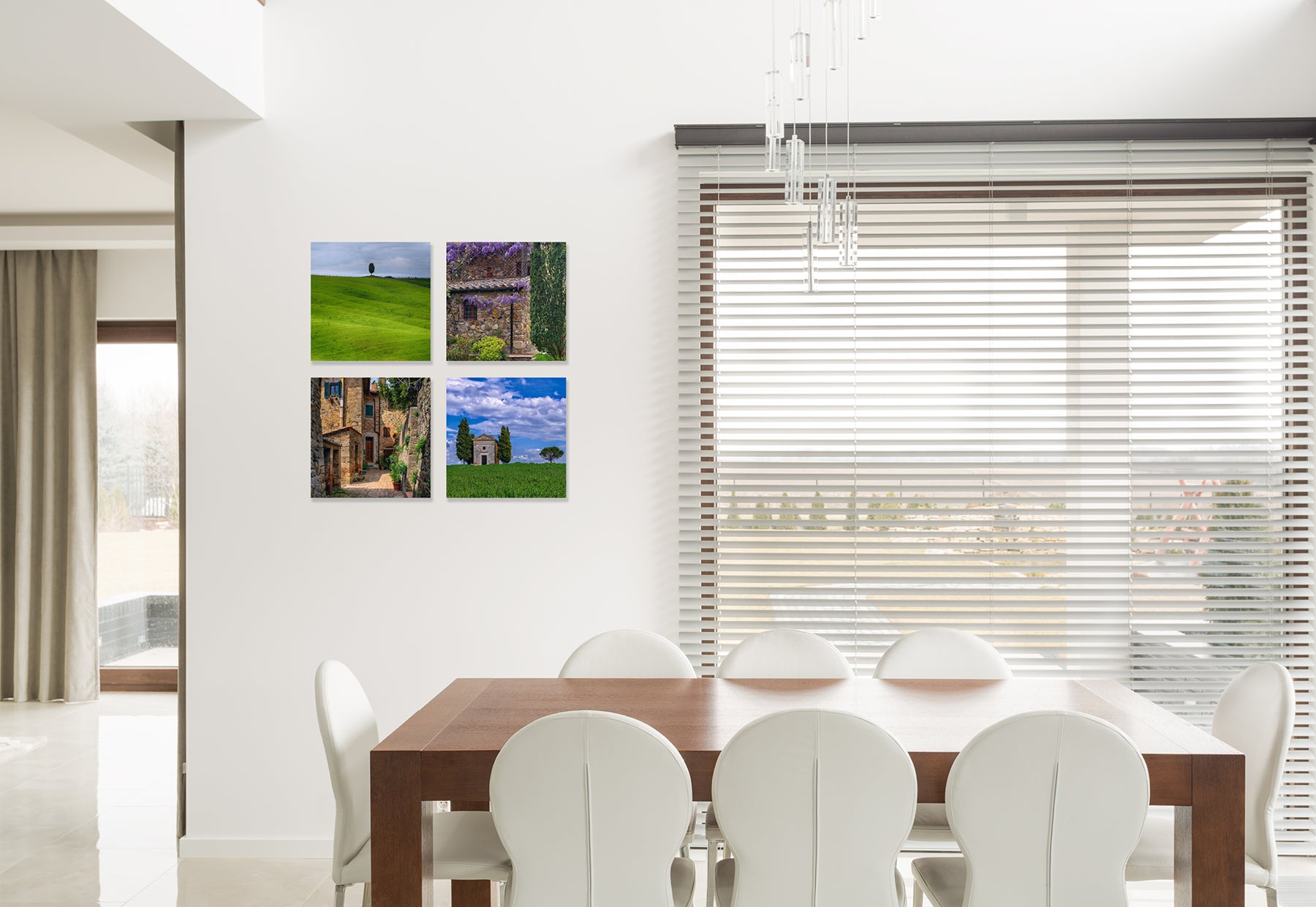 Residential dining room with brown table and white chairs featuring four framed photographs of France by Peter Lik