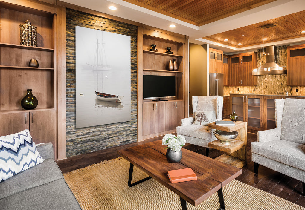 Living room with stone and wood walls featuring a framed photograph of a rowboat at the harbor in the morning mist