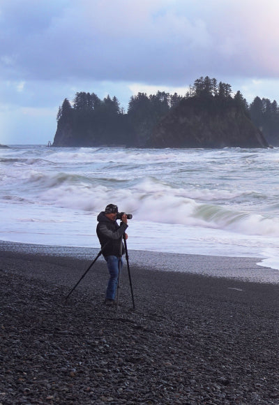 Portrait of Peter Lik wearing a heavy jacket and jeans taking a photo on beaches along Olympic Peninsula in Washington State