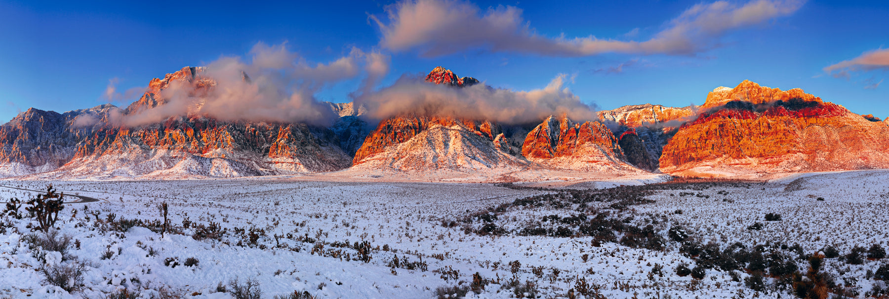 Clouds in front of the snow covered mountains and desert of Red Rock Canyon Nevada