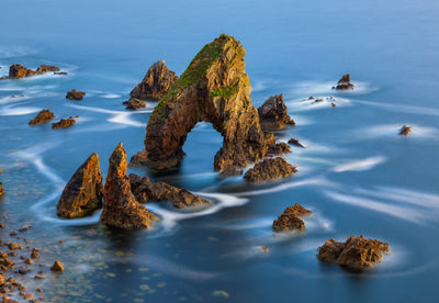 Ocean photographs of the tide swirling off rock formations on the coast of Ireland