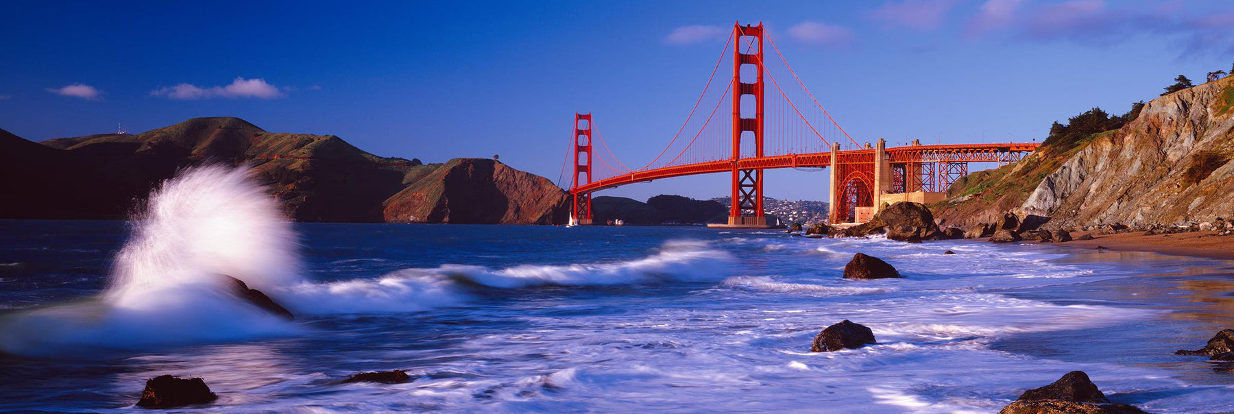 Waves crashing on the rocks of Baker Beach California with the Golden Gate Bridge in the background