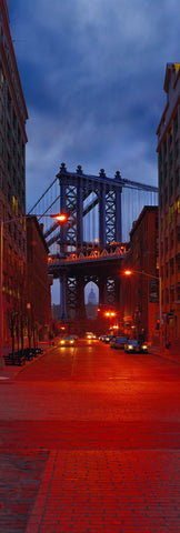 New York City street full of cars at night leading to the Manhattan Bridge