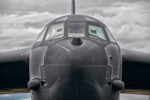 Close up of the front of a B-52 Bomber airplane with storm clouds in the background