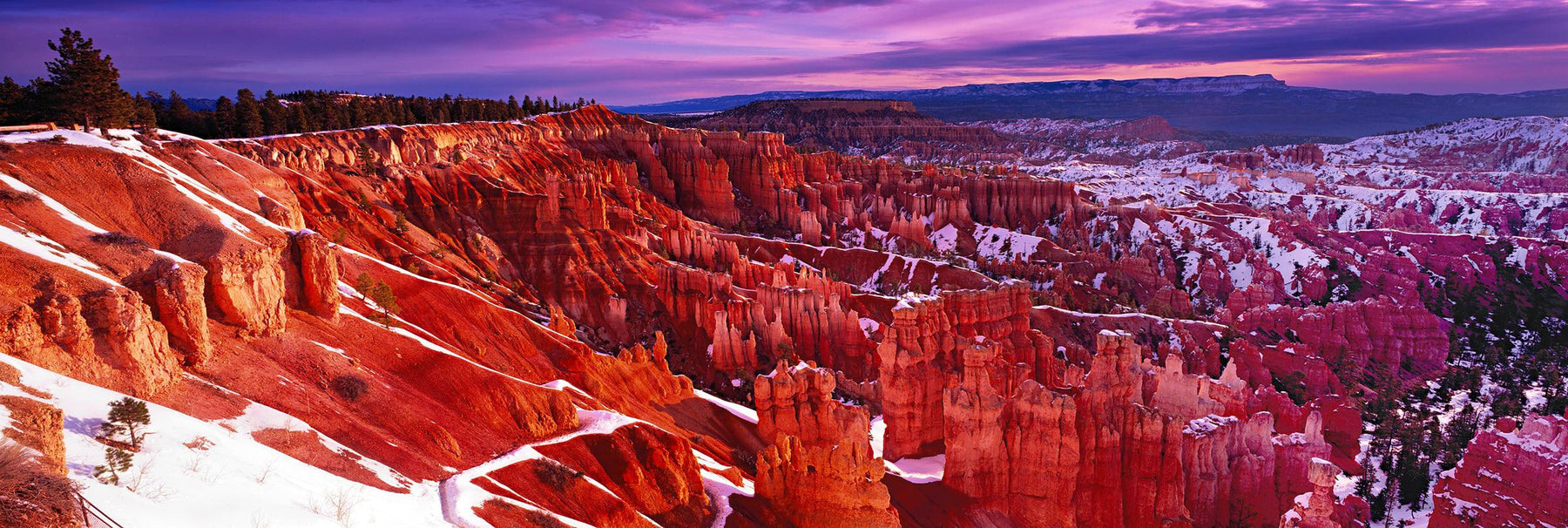 Snow covered red rock hoodoos and forest of Bryce Canyon Utah at sunset