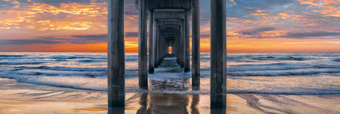 Waves crashing onto the beach and Scripps Pier in La Jolla California at sunset