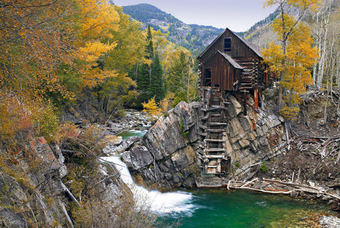 Old wooden mill sitting on a rock outcrop above the Crystal River in the forest of Crystal Colorado