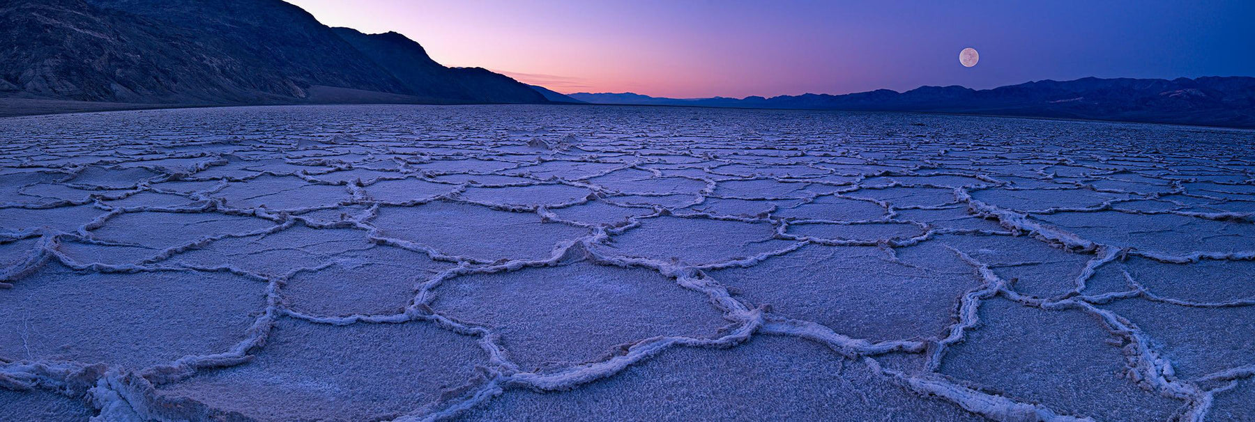 Full moon over the salt flats of Death Valley California at sunrise