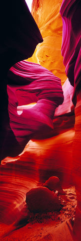 Two boulders sitting in the red orange and pink sandstone canyon of in Antelope Canyon Arizona