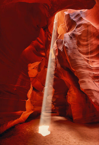 Sun light shining through the ceiling and onto the sand floor of the slot canyons in Antelope Canyon Arizona