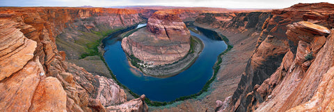 Looking down from a steep cliff into a horseshoe shaped river at Horseshoe Bend Arizona