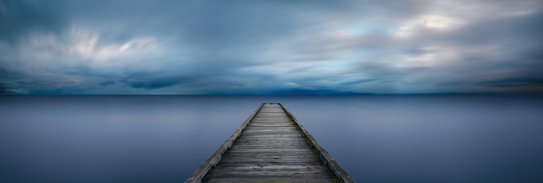 Old wood jetty stretching out over a calm lake in Seattle Washington