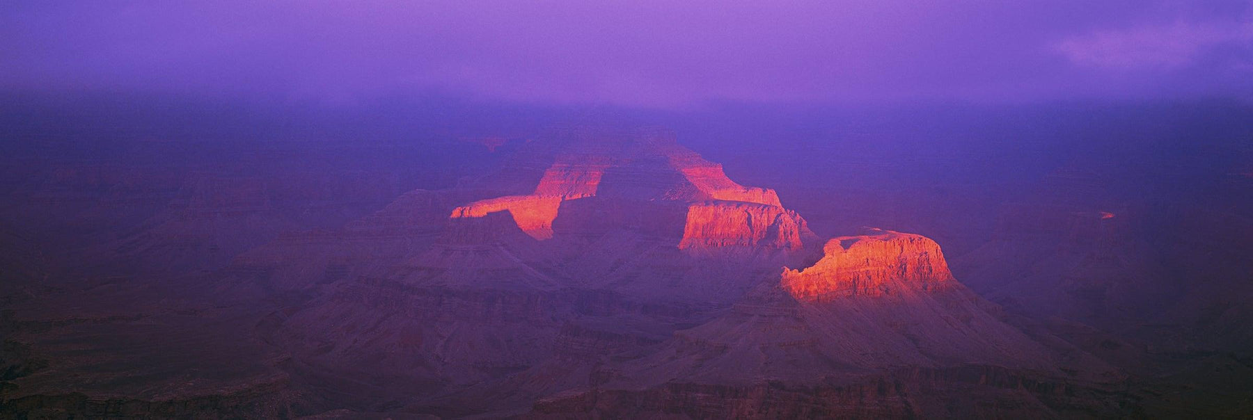 Sunlight hitting the side of the Grand Canyon Arizona during a cloudy day
