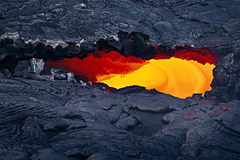 Close up of lava showing through a hole in a black lava field of Kilauea Hawaii