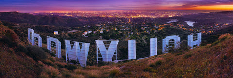 View from behind the Hollywood sign looking down over Los Angeles lit up at sunset