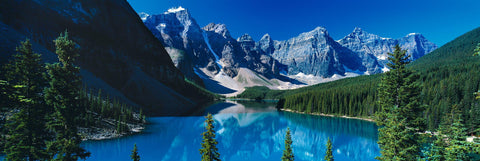 Turquoise water of Lake Moraine Canada surrounded by a forest of pine trees and rocky mountains