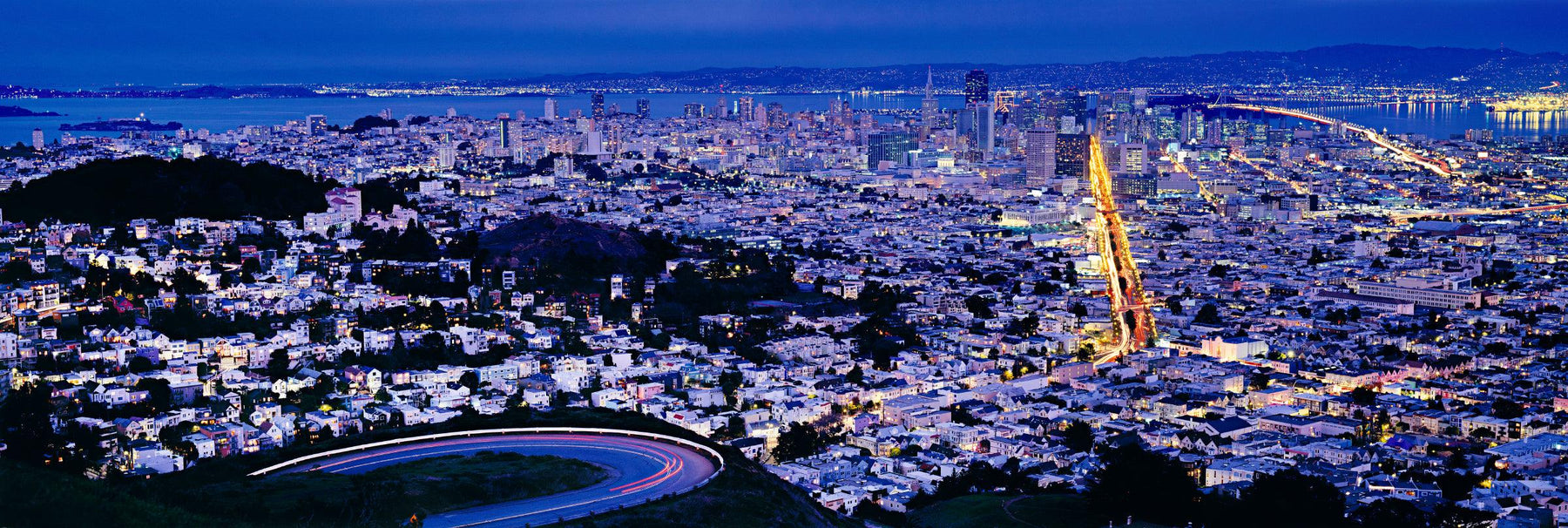 View from the hillside looking down at the lit up traffic and city of San Francisco at night