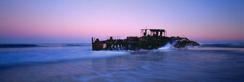 Waves crashing on the Maheno ship wreck on Fraser Island Australia at twilight
