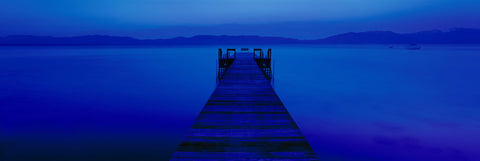 Wooden jetty stretching over Lake Tahoe under the blue monotone light of the moon