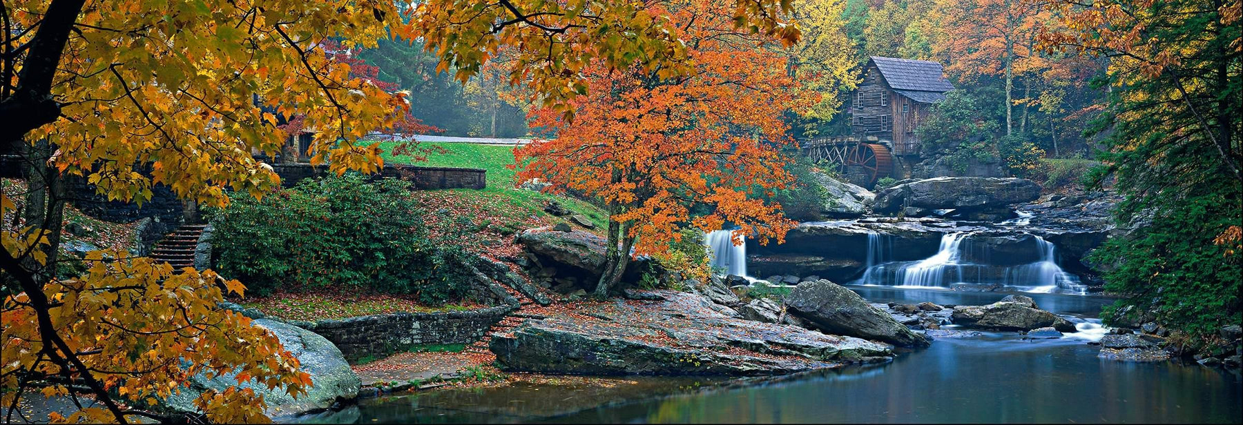 Autumn branches hanging over the rivers edge in front of  Glade Creek Grist Mill in the Appalachian Mountains