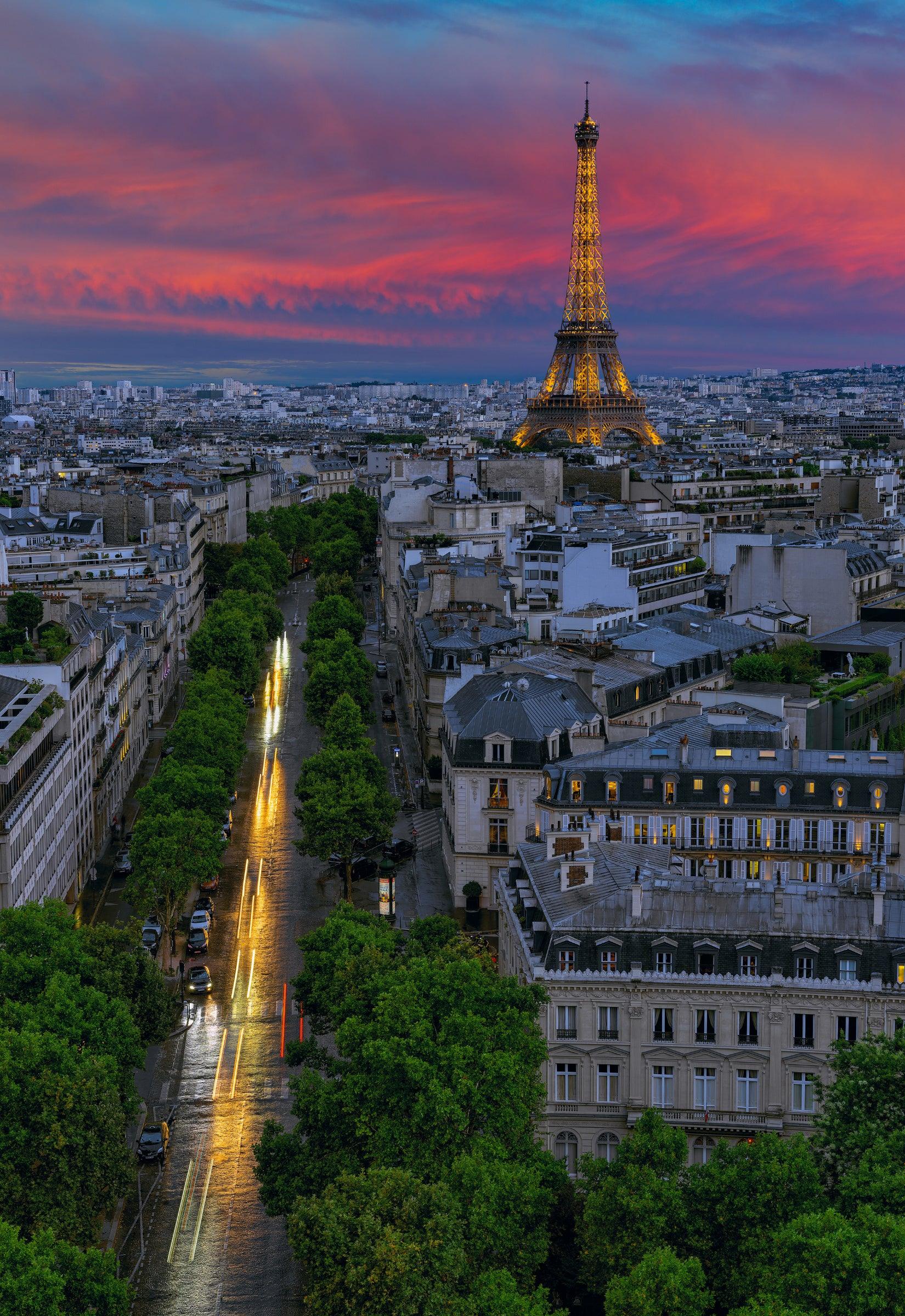Rooftop view of the streets of Paris France and the Eiffel Tower lit up at sunset