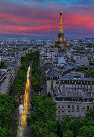 Rooftop view of the streets of Paris France and the Eiffel Tower lit up at sunset