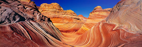 Orange and brown wave like rock formations in the slickrock hills of Vermillion Cliffs National Park Arizona