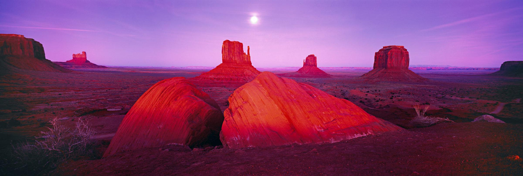 Giant sandstone formations and buttes of Monument Valley Utah during a pink sunset