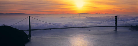 Golden Gate Bridge in front of the fog covered city of San Francisco at sunrise