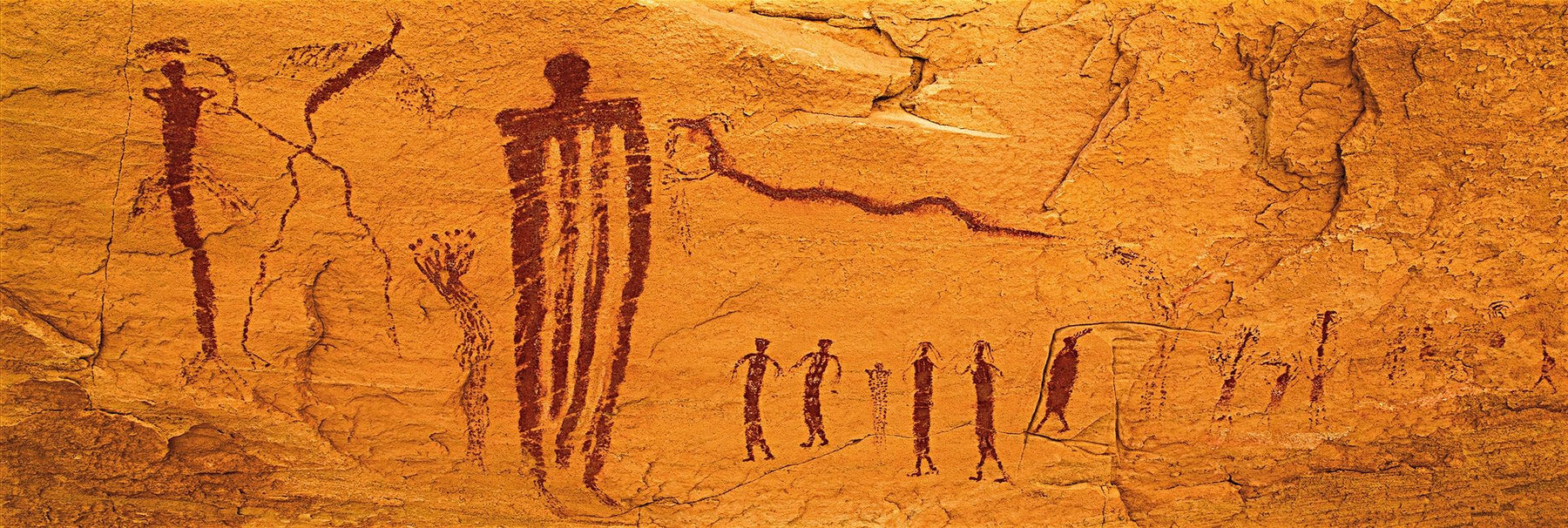 Ancient paintings on the orange rock wall of Goblin Valley Utah