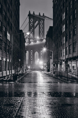Black and white wet city street at night and the Manhattan Bridge in New York 