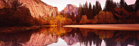 Reflection of Half Dome in a river running through Yosemite National Park with the surrounding colors of Autumn