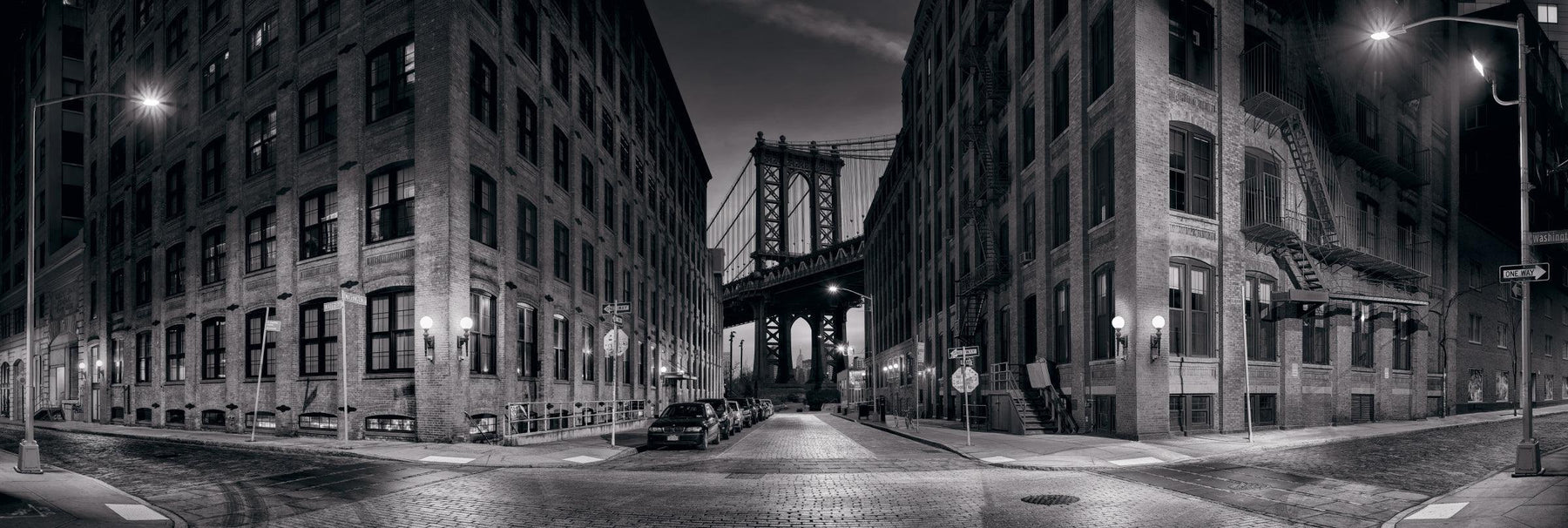 Black and white New York street and the Manhattan Bridge at dusk 